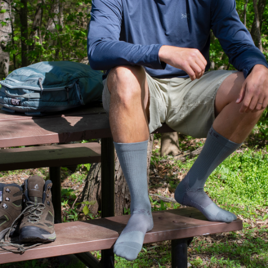 a man taking a break from hiking while wearing his OS1st socks