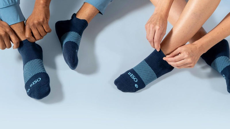 studio shot of two people wearing navy wicked comfort socks | OS1st