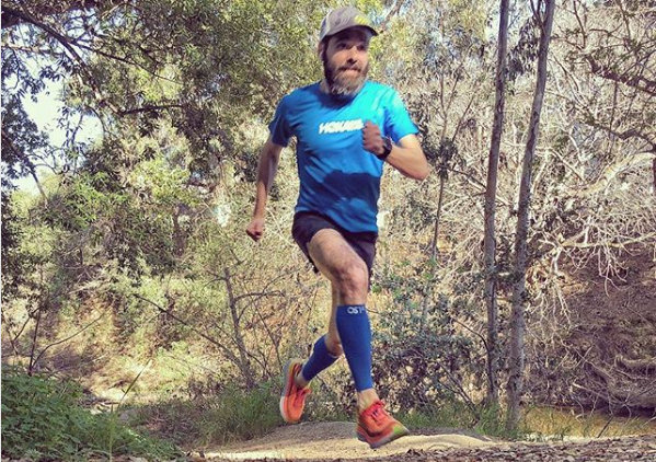 man running outdoors while wearing OS1st TA6 Calf sleeves 