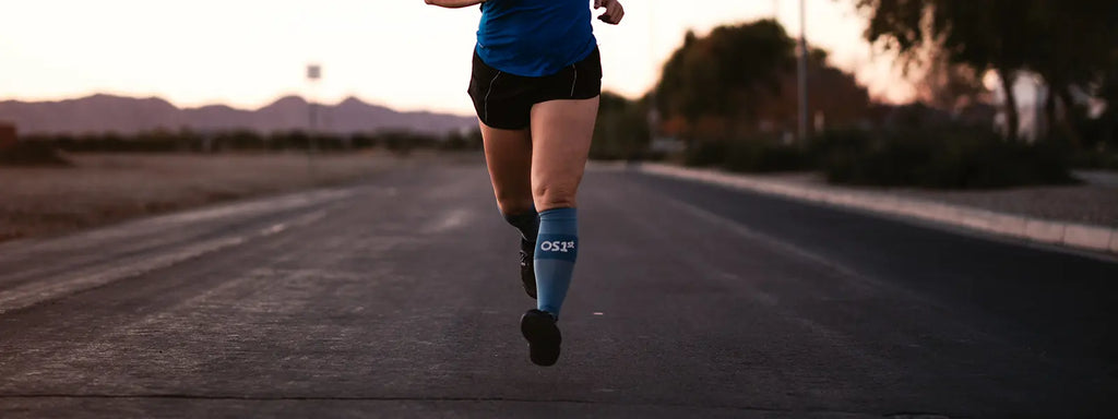 woman running in the desert while wearing OS1st compression calf sleeves
