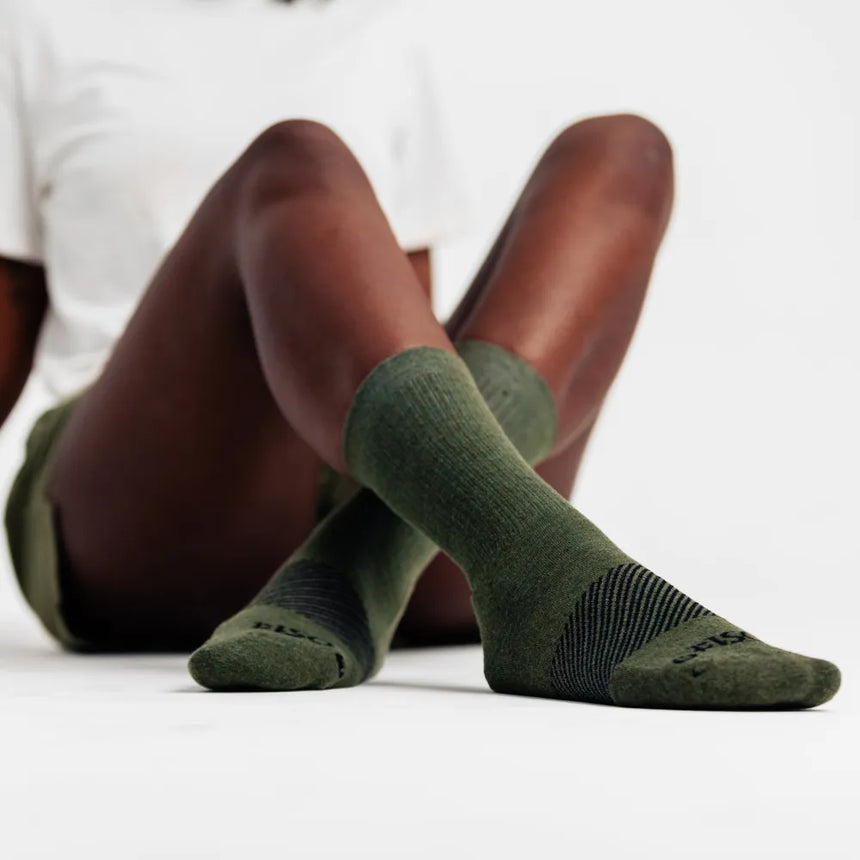 model wearing merino wool wicked comfort socks, crew in hunter green | OS1st