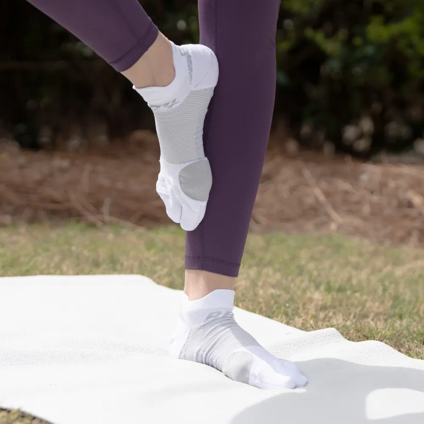 #color_white
Person doing yoga outside wearing white bunion relief socks | OS1st