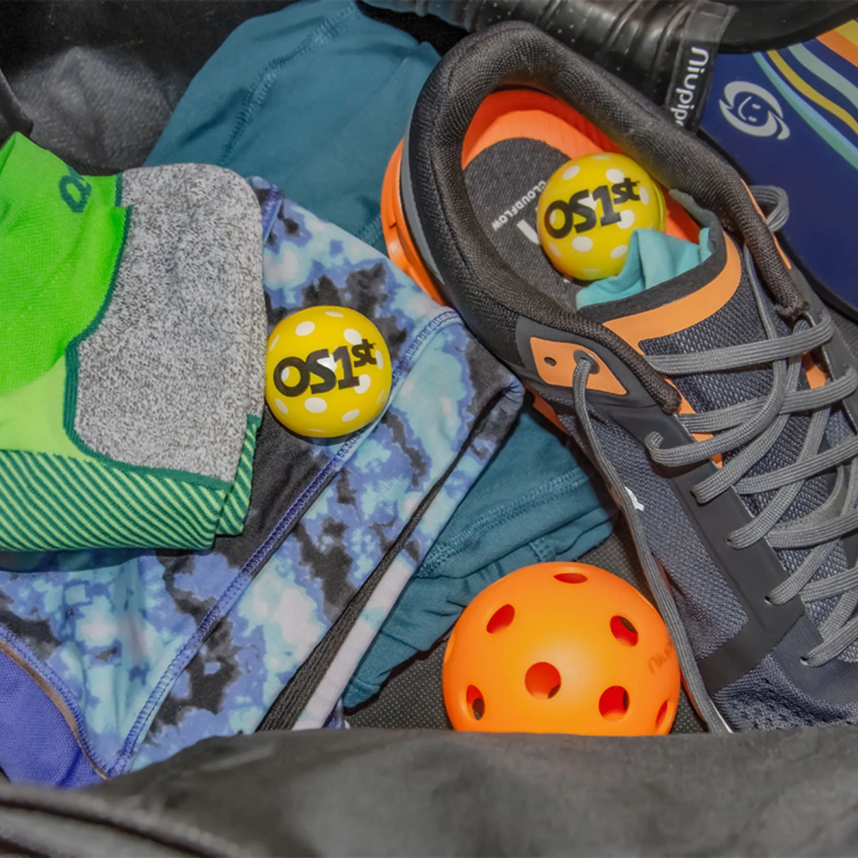 pickleball fresh snaps in a persons pickleball bag with shoes, clothing, a paddle, a pickleball, and a pair of the pickleball socks | OS1st