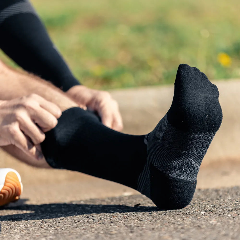 Runner wearing black crew plantar fasciitis socks | OS1st