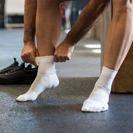 athlete wearing white quarter crew plantar fasciitis socks | OS1st
