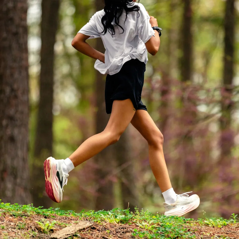 person running on a trail in the woods wearing quarter crew wicked comfort socks in white | OS1st