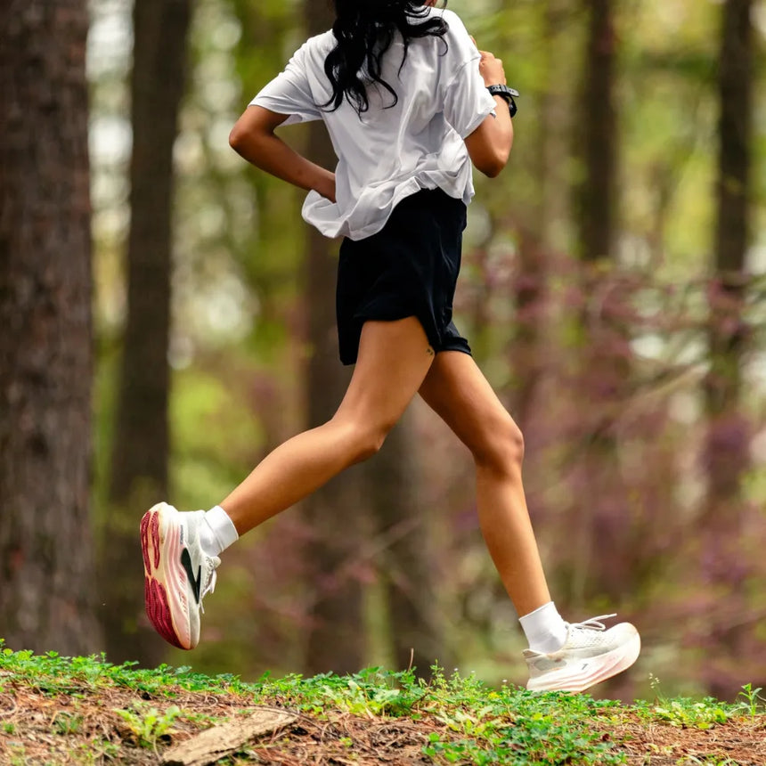 person running on a trail in the woods wearing quarter crew wicked comfort socks in white | OS1st