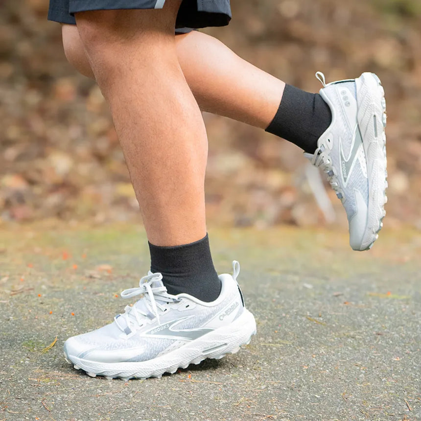 person running on a trail wearing quarter crew wicked comfort socks in black | OS1st