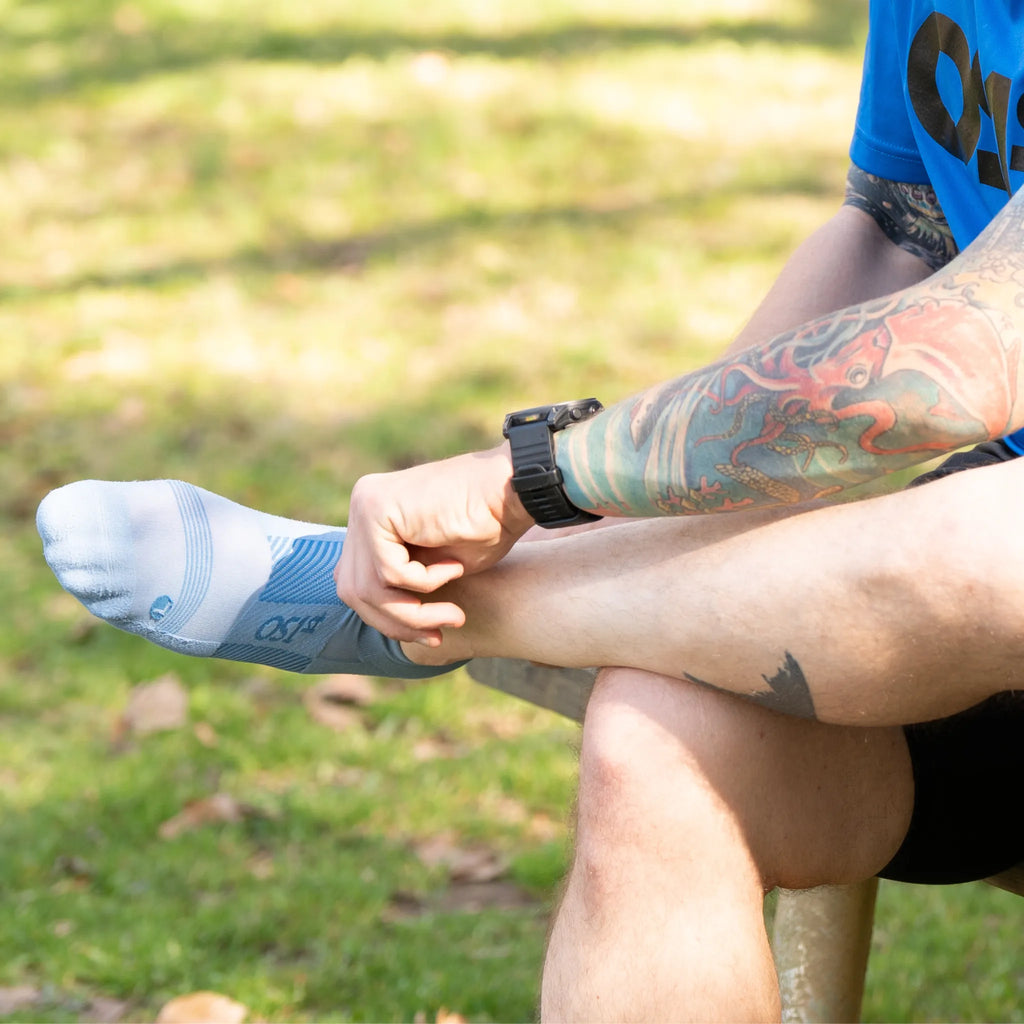 Male runner putting on thin air performance socks in steel blue | OS1st