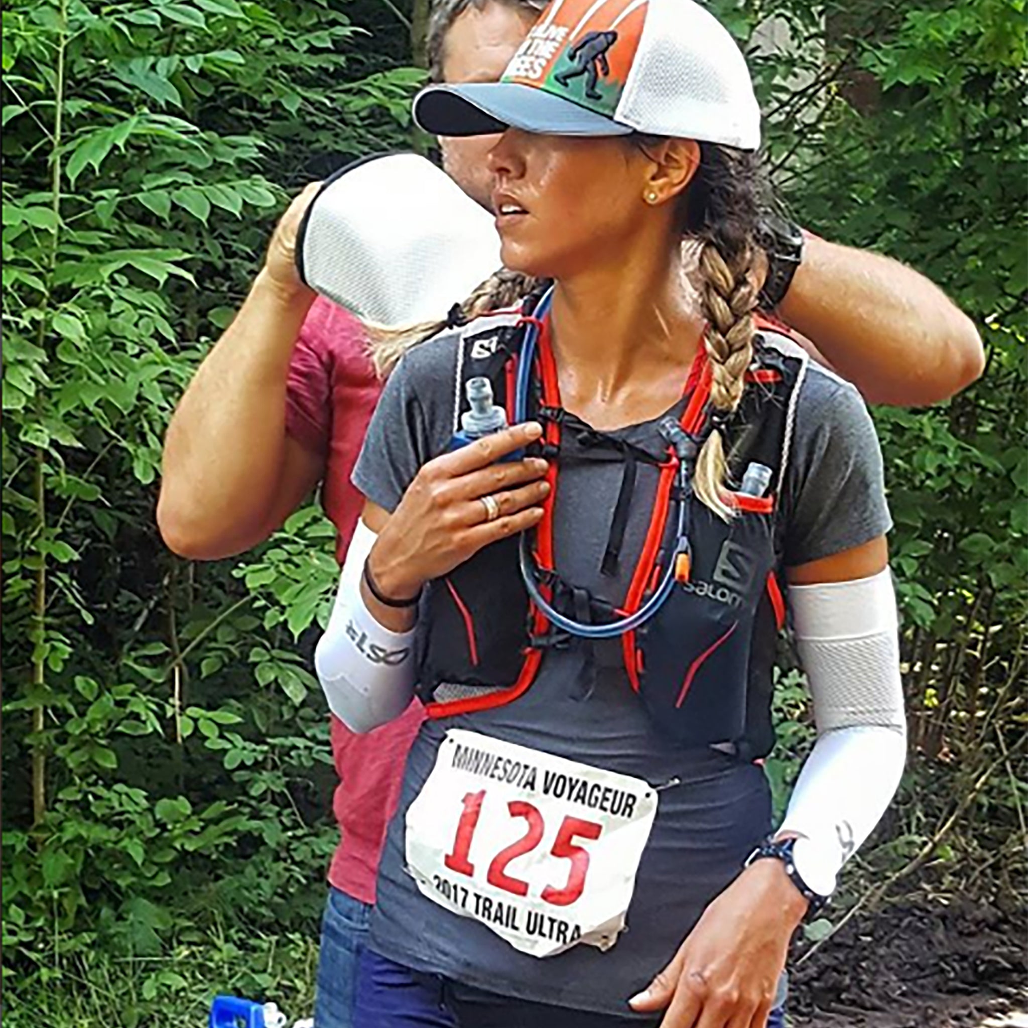 A woman running a trail shown wearing two of the AS6 performance arm sleeves | OS1st