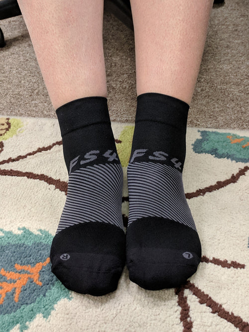 a person wearing the black quarter crew length FS4 socks